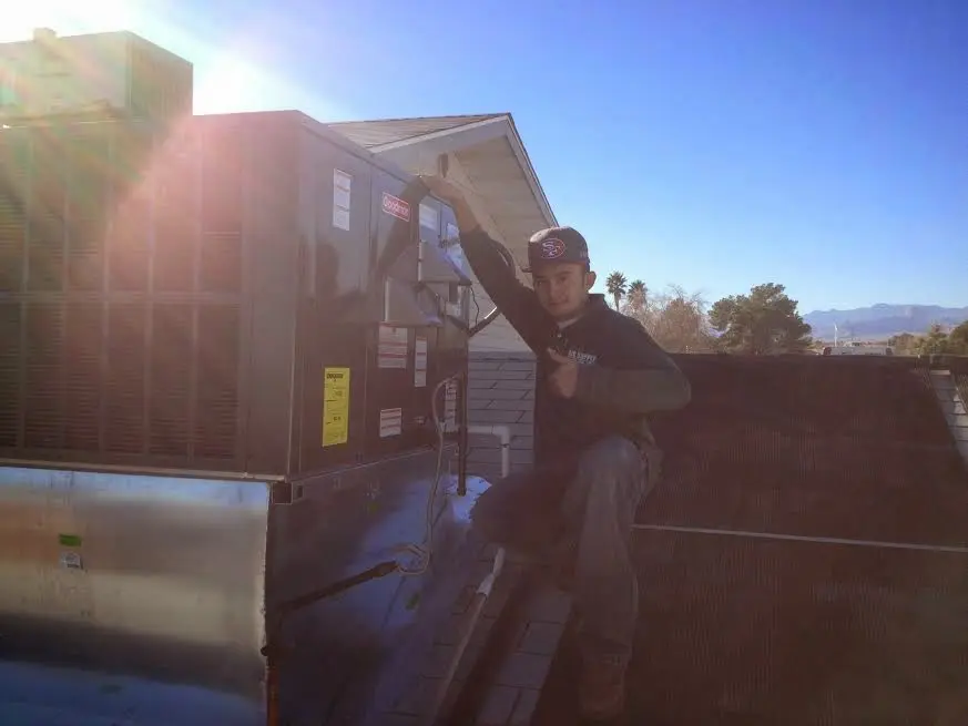 HVAC technician performing AC Tune-Up on a rooftop unit in Big Lake